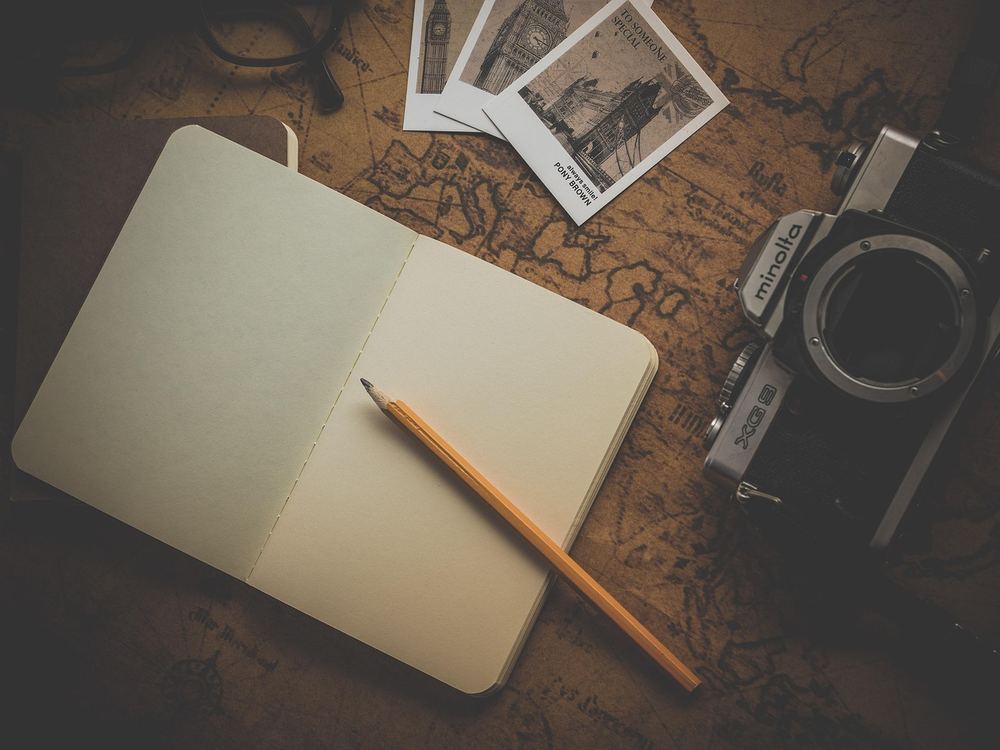 A notebook and map used for planning a UK trip